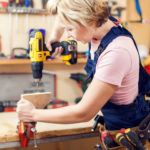 Young handy woman with short blond hair working with screwdriver.